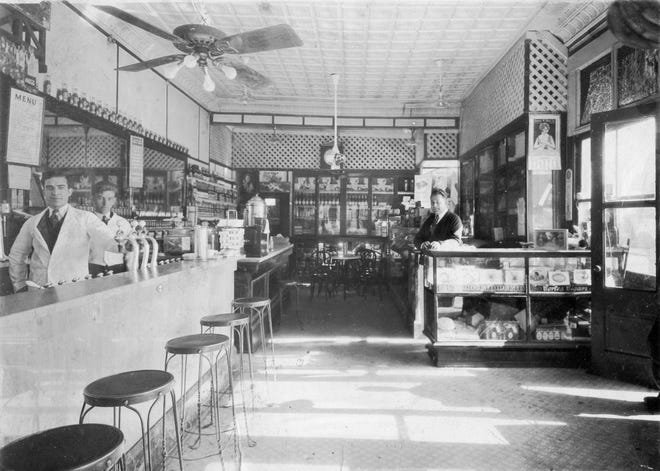 Basil Leopold and soda jerk Whatley Bragg stand behind the soda fountain in the Leopold's shop at the corner of Gwinnett and Habersham streets in the 1940s. Peter Leopold is behind the register.