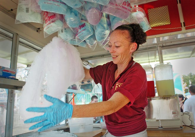 Patty, a carnival worker who did not want to give her last name, makes cotton candy at the Marshfield Fair.