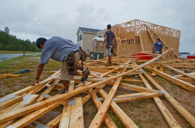 A construction crew moves roof trusses for a new home under construction in Spring Lake at the Highlands. Richard Burkhart/Savannah Morning News