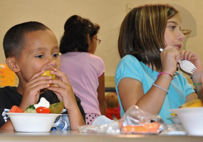 Kavon Houston (left), 7, and Jordyn Wills, 7, both second-graders at Maple Elementary School, eat fresh fruit Thursday, Aug. 27, 2009, thanks to a grant providing fresh fruits and vegetables twice weekly at the school.
