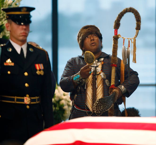 A shaman pauses for a brief ritual in front of the flag-draped casket of Sen. Edward M. Kennedy as he pays his respects at the John F. Kennedy Presidential Library in Boston today.