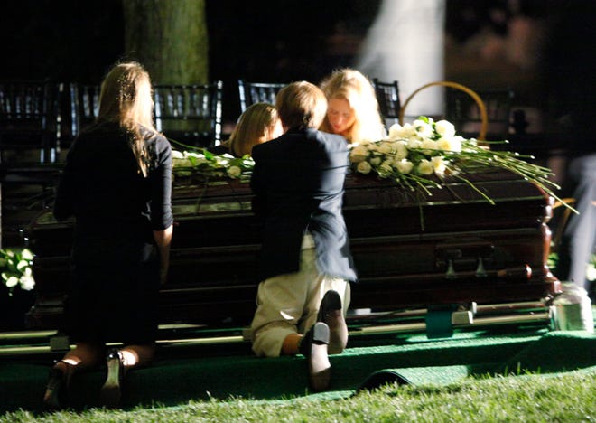 Sen. Edward Kennedy's grandchildren and family members kneel over his coffin during his burial service at Arlington National Cemetery in Arlington, Va., on Saturday.
