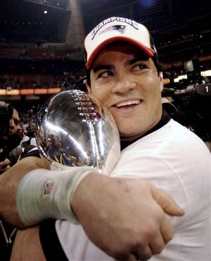 New England Patriots linebacker Tedy Bruschi, shown in this Feb. 1, 2004 photo, hugs the Vince Lombardi Trophy after the Patriots beat the Carolina Panthers 32-29 in Super Bowl XXXVIII in Houston. According to reports from The Associated Press, Bruschi announced his retirement from the team at a news conference today.