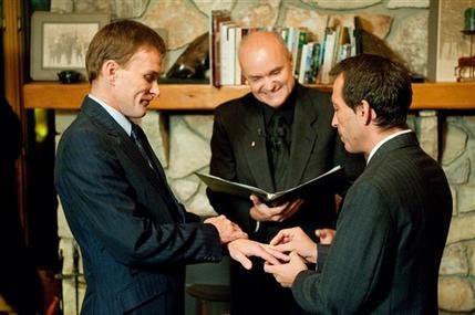 Bill Slimback, left, and Bob Sullivan, both of Whitehall, N.Y., exchange rings during their wedding ceremony at Moose Meadow Lodge in Waterbury, Vt., while Justice of the Peace Greg Trulson, center, who is a co-owner of the lodge, officiates on Tuesday, Sept. 1, 2009.
