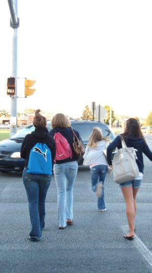 Several Waynesboro high and middle school students hurriedly cross East Main Street at the intersection of Mickley Avenue and Second Street near the YMCA this morning. Waynesboro and Washington Township residents are concerned for safety because new traffic signals no longer allow an exclusive four-way pedestrian stop at the intersection.