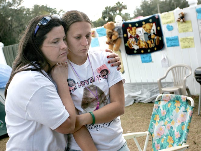 Davina Peeples, left, comforts Crystal Sheffield, mother of missing five-year-old Haleigh Cummings, while at a shrine honoring Haleigh at the corner of East Buffalo Bluff Road and Tyler Street in Satsuma, Florida, Thursday, February 26, 2009.