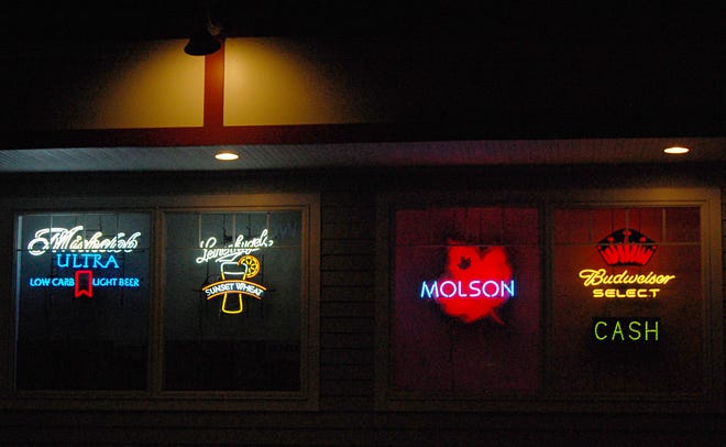 Neon signs advertising alcoholic beverages, like these in the windows of Plympton Convenience store, are a point of contention for Plympton resident Tim Dempsey.