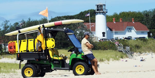 Vince Gulotta, one of two Chatham beach supervisors, keeps an eye out for sharks at Lighthouse Beach yesterday. A state shark alert for waters off Chatham is drawing television crews and binocular-armed nature lovers to the Lighthouse Beach overlook.