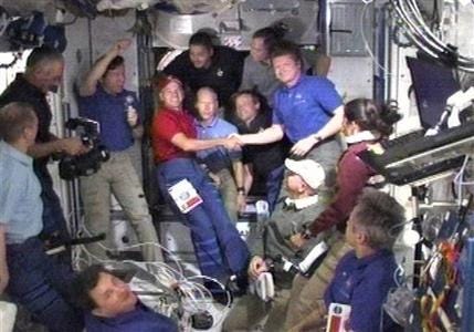 In this image made from video provided by NASA astronaut John "Danny" Olivas, STS-128 mission specialist, center left, shakes hands and thanks the commander of the space station Russia's Federal Space Agency cosmonaut Gennady Padalka before the hatches between the orbiting shuttle and station close Monday Sept. 7, 2009. The shuttle will undock Tuesday.