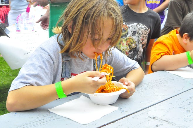 Cheyann Kevilus, 8, eats enough spaghetti to take first place in the 6-7-8 age group of the spaghetti-eating contest at the event.
