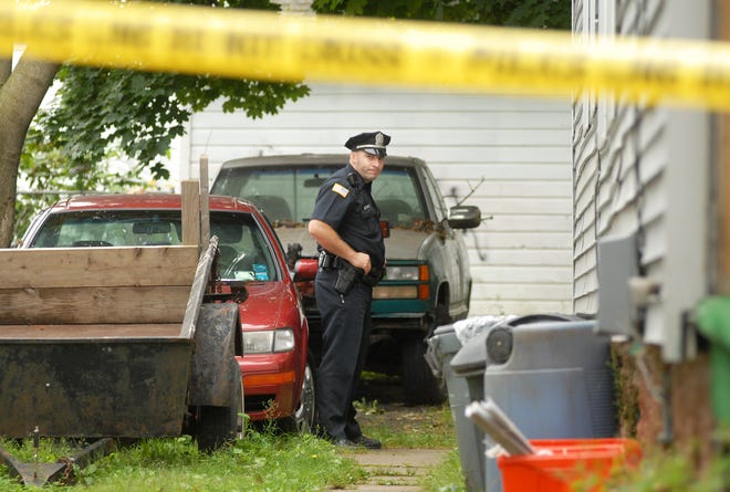 Utica police officer Serif Seferagic guards the back entrance to 1647 Steuben Street after a shooting, Saturday, September 12, 2009 in Utica.