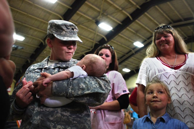 Spc. Jaime Wagy holds her three-month-old nephew, Colby, for the first time Friday after she and the rest of Company C of the 634th Brigade Support Battalion returned from Afghanistan.