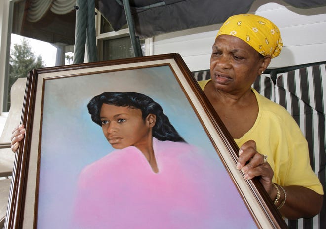 Bessye Middleton holds a painting of her daughter, Tryna, who was raped and fatally stabbed on Sept. 21, 1984. The 14-year-old was walking home after a football game.