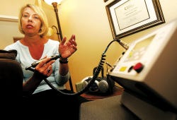 Photo by Amy Paterson/New Jersey Herald
 Carolyn Monday, owner of Laser Works Treatment Center in Hackettstown, explains how her low-level laser therapy works at her office in Hastings Square Thursday. Monday treats clients for smoking cessation and weight loss.