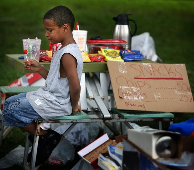Trey Brunson, 7, watches over his snack stand during a yard sale held by former Taylor, Bean & Whitaker employees on Saturday in Belleview..