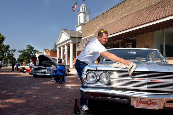 Kevin Garrison of Mackinaw polishes his 1965 Chevy Malibu on Sunday during the Art Rod Festival in Metamora.