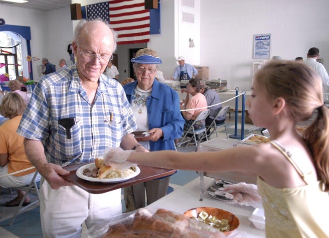 James Rock of Norwich , left, and Anna Mae Burr of Ledyard gets bread with their meals from Kathryn Wyland, 13, of Voluntown, Sunday, Sept. 13, 2009 on the last day of the 34th annual Greek Festival at the Holy Trinity Greek Orthodox Church in Norwich.