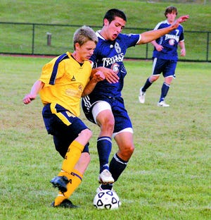 G-A’s Taylor Kirkpatrick (left) battles Chambersburg’s Andrew Collier for the ball in a varsity soccer match Monday in Greencastle.