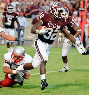 Texas A&M running back Cyrus Gray (32) runs through New Mexico's Ian Clark, left, for a 13-yard touchdown during the second quarter of an NCAA college football game Saturday, Sept. 5, 2009 in College Station.