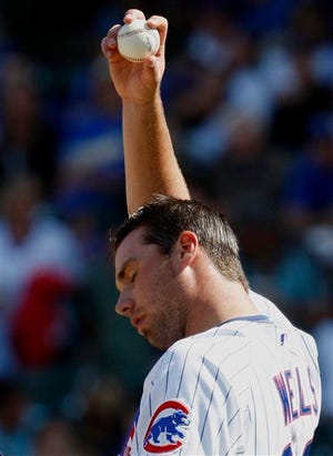 Chicago Cubs starter Randy Wells wipes is face during the third inning of a baseball game against the Milwaukee Brewers in Chicago, Thursday, Sept. 17, 2009.(AP Photo/Nam Y. Huh)