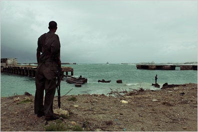 Last month in Mogadishu, a government soldier watched as people swam in the Indian Ocean.