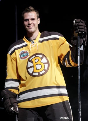 David Krejci displays the jersey the Bruins will wear in the game at Fenway Park on Jan. 1.