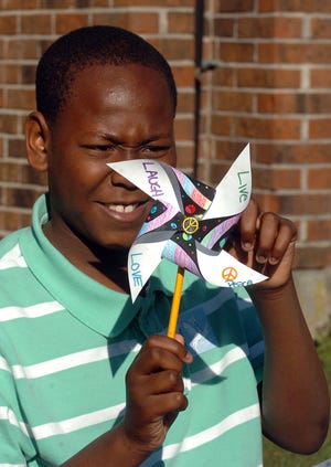 Phillip Obas, an eighth-grade student at Teachers' Memorial Middle School, tests a pinwheel Monday, September 21, 2009 during the 4th annual Pinwheels for Peace at the Norwich school.