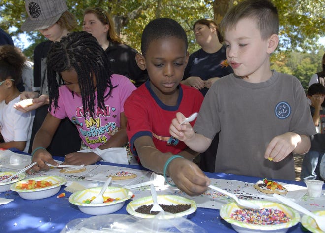 Arienne Souvenance, 8, of Norwich, left, Noah Lucien, 8, of Norwich, and Colin Glenn, 8, of Eastford, decorate their cookies Sunday, Sept. 20, 2009 during Family Day at Mohegan Park in Norwich.