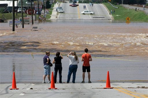 Bystanders watch Sweetwater Creek rage across a highway after heavy flooding from recent days of heavy rain, Tuesday, Sept. 22, 2009, in Austell, Ga.