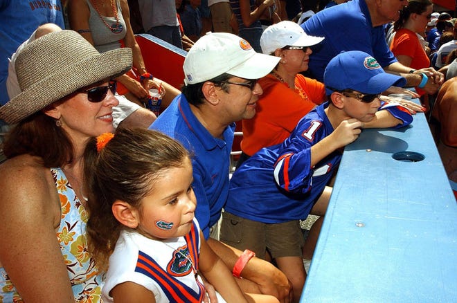 Karen, left, and Bruce C. Barber watch the Florida game against Ole Miss with their children, Chloe and Payton, at Florida Field on Oct. 4, 2003. A small plane belonging to Bruce Barber crashed in the Everglades on Sunday. Authorities have not identified the crash victims, but friends of the family believe Bruce, Karen and Payton Barber were on the plane. Friends said Chloe stayed behind in South Florida.