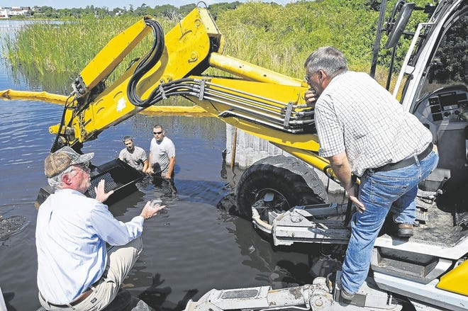 In this July file photo, Roger Griffiths, left, and Dale Thacker, right, talk over the placement of the boat ramp extension on Lake Martha in Winter Haven. Wednesday, July 22, 2009.