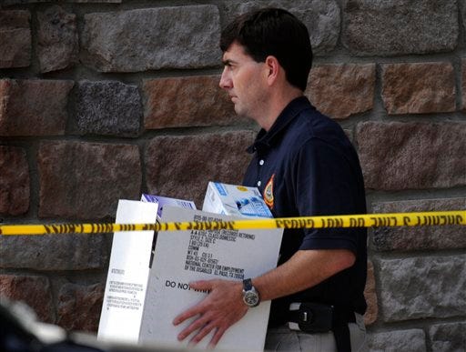 A federal agent carries a box Wednesday, Sept. 16, 2009, with items from the apartment of Najibullah Zazi in Aurora, Colo.