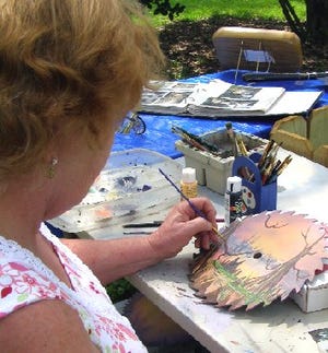 Peg Carbo, artist with Lagniappe Art and Crafts, adds her finishing touches to her artwork.