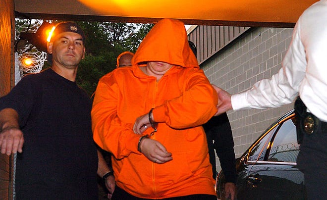 Accused serial bank robber Heather Brown of Norwich is escorted Detective Dean Peluso of the Eastern District Major Crime Squad Monday, September 28, 2009 in to Troop E in Montville.