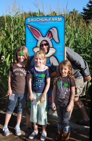 Rick Hynes, of Scituate, as the bunny, and daughter Emma, left, Shannon Burgess and Neve Sanella enjoy the Sauchuk Farm Corn MAiZE.