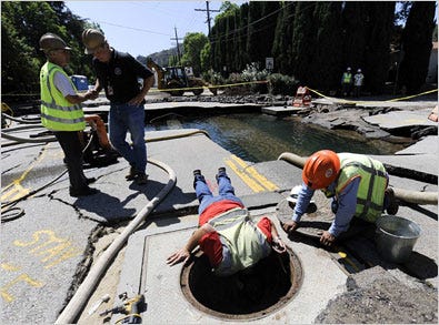 Municipal workers pumped water from a large hole on a street in the Studio City section after one of many water main breaks in Los Angeles this month.