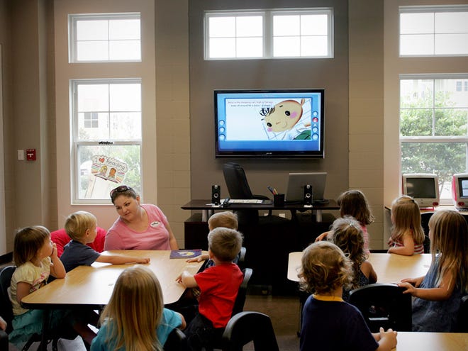 Preschoolers at KidWorks in Town of Tioga listen watch as their teacher conducts a lesson using one of the school's new 52-inch flat screens. Children are being introduced to computers at a younger age as school's incorporate technology into the classroom.