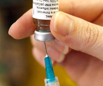 In this Aug. 11, 2009, file photo, a dose of the experimental vaccine for the Swine flu virus is prepared at Vanderbilt University Medical Center in Nashville, Tenn.