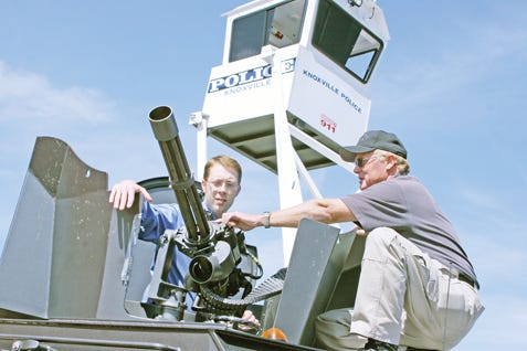 Chris Tucker, a Y-12 audio visual specialist, left, gets a close look at the Dillon Gatling Gun from Security Officer Malcolm Johnson Thursday at the Oak Ridge Regional Emergency Management Forum at the New Hope Center on Scarboro Road. Johnson works for Wackenhut Services Inc. Oak Ridge.