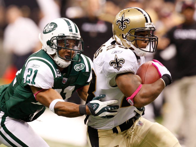 New Orleans Saints running back Pierre Thomas (23) tries to get away from New York Jets cornerback Dwight Lowery (21) in the first half of Sunday’s game in New Orleans.