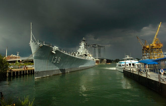 Berthed at the Fore River shipyard in Quincy, the USS Salem with dark clouds overhead.