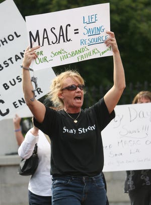 Joanne Peterson of Raynham, Learn To Cope founder, demonstrates outside the Statehouse on Sept. 22 to protest the planned closing of a Bridgewater drug treatment center.
