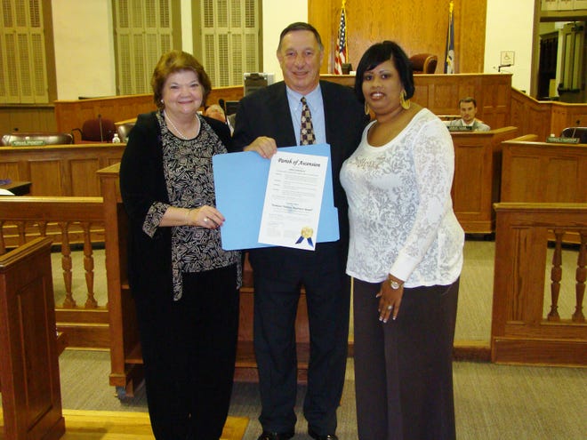 Martha Forbes (left), executive director of the Capital Area Family Violence Intervention Center, and Kimberlee Brown, Ascension Advocate for the organization, flank Parish President Tommy Martinez at the Oct. 1 Parish Council meeting in Donaldsonville. Martinez presented a proclamation declaring October to be Domestic Violence Awareness Month in Ascension Parish.