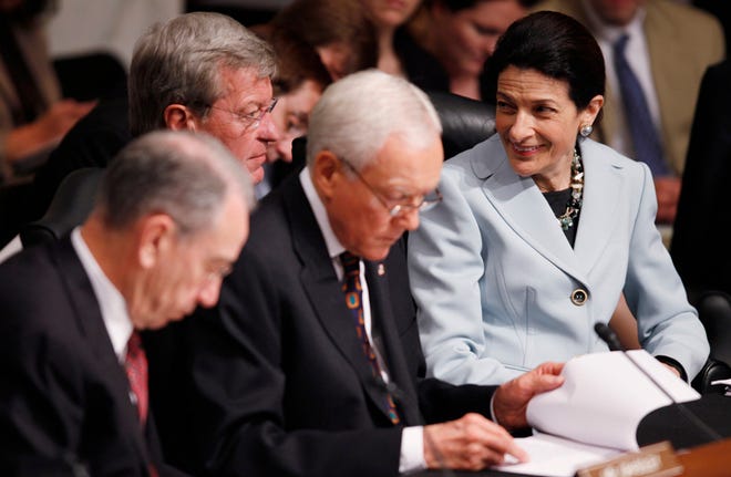 Senate Finance Committee member Sen. Olympia Snowe, R-Maine, right, smiles as speaks with Senate Finance Committee Chairman Sen. Max Baucus of Mont., second left, as her Republican colleagues Sen. Orrin Hatch, R-Utah, center, and the committee's ranking Republican Sen. Charles Grassley, R-Iowa, look on during the committee's hearing regarding health care reform, Tuesday, Oct. 13, 2009, on Capitol Hill in Washington. Snowe says she will vote for a Democratic health care bill, breaking with her party on President Barack Obama's top legislative priority.