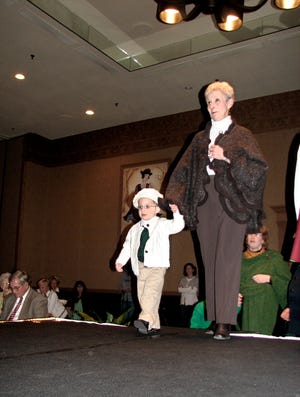 Seamus Dwyer, 2, of West Peoria takes the runway with his grandmother Trish Flynn of West Peoria at The Salvation Army Women's Auxiliary Style Show on Tuesday at the Holiday Inn City Centre. Both modeled clothing from Harp & Thistle Imports Ltd.
