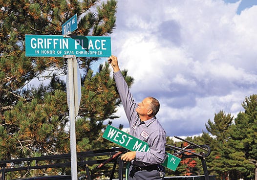 The citizens of Kincheloe recently renamed one of their streets in honor of Sgt. Christopher Griffin, who perished in Afghanistan on October 3 while serving his country in the U.S. Army. Here, Kinross Department of Public Works Maintenance employee Ed Benoit adjusts the sign for Griffin Place — formerly known as West Market Place.