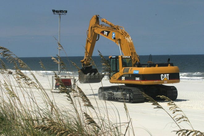 StaffA tractor pulls one of the lights that was used for the 2005 beach renourishment project along Atlantic Beach.