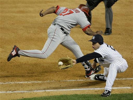 New York Yankees' Mark Teixeira stretches to take the throw from catcher Jose Molina on a dropped third strike call on Los Angeles Angels' Vladimir Guerrero (27) during the fourth inning of Game 2 of the American League Championship baseball series Saturday, Oct. 17, 2009, in New York.
