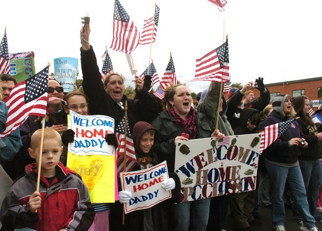 Outside the Taunton Armory, relatives of members of the National Guard 772nd Military Police Company wave to members of the unit, just back from Iraq. In front from left are Neil Wells Jr. of Middleboro, waiting for his dad, Neil Wells; Alexis Closson, 12, and her brother Noah, 11, of Attleboro, waiting for their father, Shawn Closson; and Closson’s cousin Crystal Breese, 24, of Whitman. Behind Noah is Closson’s mother, Rose Ann Closson of Easton.