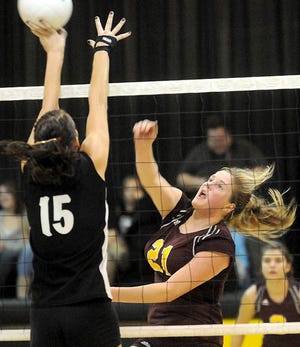 Stockton's Haley Magee hits a shot off of Lena-Winslow blocker Kate McIlvanie in Lena on Tuesday.